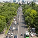 Rua arborizada em cidade brasileira sem carros, mostrando ciclistas e pedestres circulando livremente em um ambiente urbano sustentável.