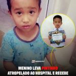 Menino segurando um pintinho ferido e uma nota de dinheiro em gesto de compaixão e inocência.