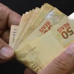 Notas de Real brasileiro empilhadas de forma organizada, simbolizando o novo piso salarial de 2.100 reais.