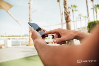 Ilustração de um smartphone exibindo aplicativos de apostas esportivas com um martelo de juiz ao lado, simbolizando a proibição legal no Brasil.