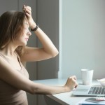 Pessoa expressando preocupação ao segurar contas e boletos, com a mão sobre o peito, simbolizando o impacto do estresse financeiro na saúde do coração.