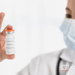 Close-up de frascos de antibióticos e comprimidos descartados em meio ao lixo comum, representando o risco ambiental.