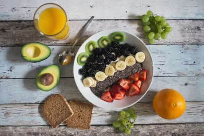 Variedade de frutas, legumes e verduras frescas coloridas dispostas sobre uma mesa, representando a recomendação nutricional da OMS.
