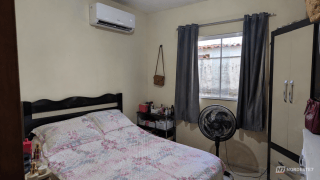 Ar-condicionado split instalado na parede e ventilador de teto em movimento no mesmo ambiente, ilustrando eficiência energética.