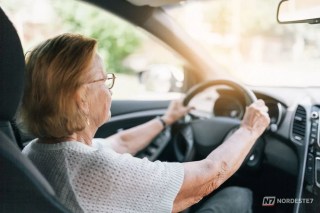 Idoso sorridente segurando o volante de um carro, representando a continuidade da CNH para motoristas acima de 70 anos no Brasil.