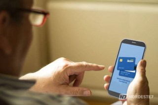 Pessoa idosa analisando atentamente o extrato de benefício no aplicativo Meu INSS em um smartphone para identificar descontos irregulares.