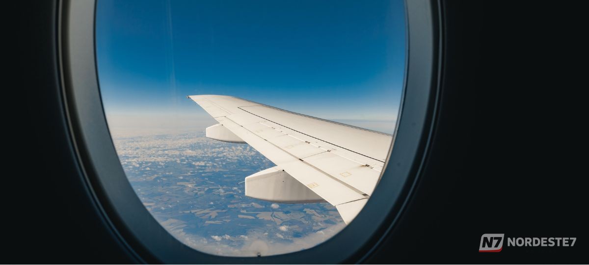 Passaporte e passagem de avião em destaque com um aeroporto ao fundo, representando as possíveis mudanças na exigência de documentos obrigatórios para viagens internacionais.