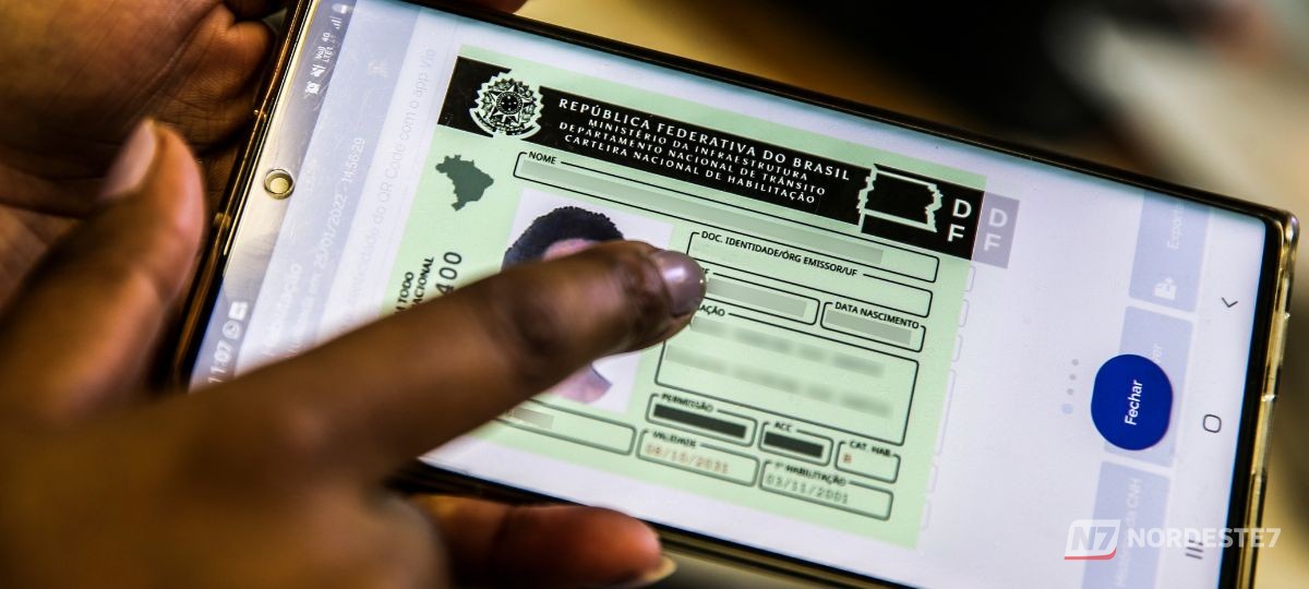 Carteira de habilitação brasileira (CNH) em destaque sobre uma mesa de atendimento, representando o processo de renovação do Detran.