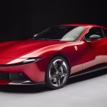 Novo carro esportivo vermelho da Ferrari exposto em uma concessionária de luxo no Brasil, destacando seu design aerodinâmico e o icônico logotipo do cavalo empinado na frente.