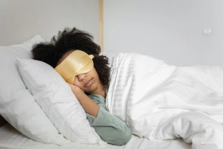 Pessoa jovem dormindo tranquilamente em uma cama confortável com luz solar suave entrando pela janela, ilustrando o sono saudável e o cronotipo noturno.