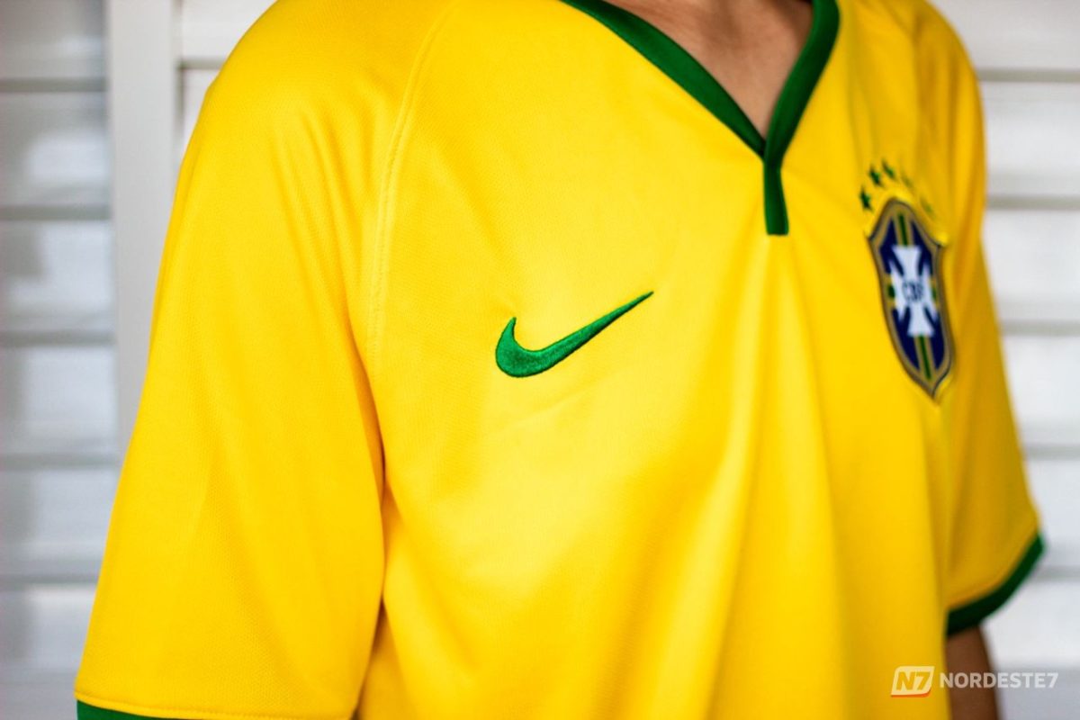 Neymar Jr. com expressão de lamentação vestindo a camisa amarela da Seleção Brasileira de futebol.
