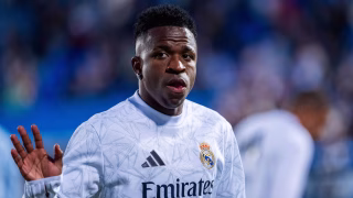 Montagem lado a lado dos jogadores de futebol brasileiros Vinicius Jr., sorrindo com a camisa do Real Madrid, e Neymar Jr., com expressão pensativa, ilustrando a comparação de seus salários milionários.