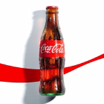 Lata de Coca-Cola Zero sob iluminação de estúdio ao lado de um copo com gelo e refrigerante.