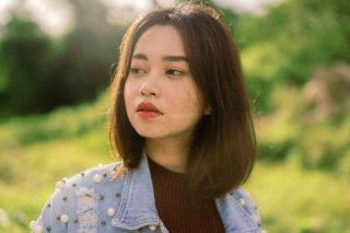 Mulher com cabelo de comprimento médio em tom castanho iluminado, demonstrando um corte leve que suaviza as feições do rosto.