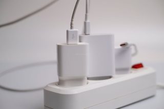 Tomada elétrica com diversos plugues de eletrodomésticos e eletrônicos conectados em modo standby.