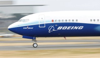 Membros de sindicato seguram cartazes de protesto em frente a uma unidade industrial da Boeing.