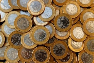 Monitor financeiro exibindo gráficos de oscilação das taxas de juros futuros e índices do mercado financeiro.