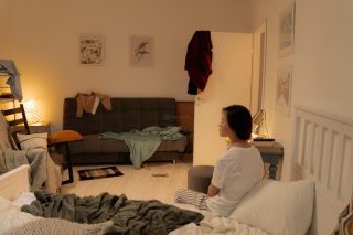 Quarto com roupas espalhadas pela cama e chão, ilustrando a bagunça e a falta de organização pessoal.